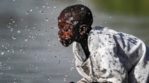 TOPSHOT - A boy splashes himself with water in the Atbarah river near the village of Dukouli within ...