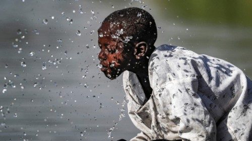 TOPSHOT - A boy splashes himself with water in the Atbarah river near the village of Dukouli within ... TOPSHOT - A boy splashes himself with water in the Atbarah river near the village of Dukouli within ...