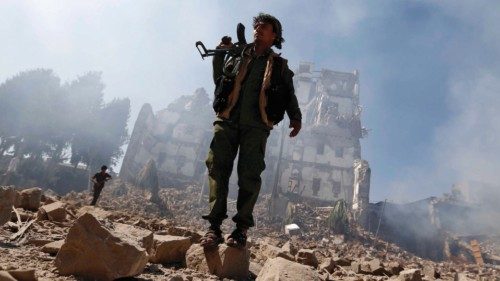 Huthi rebel fighters inspect the damage after a reported air strike carried out by the Saudi-led ...