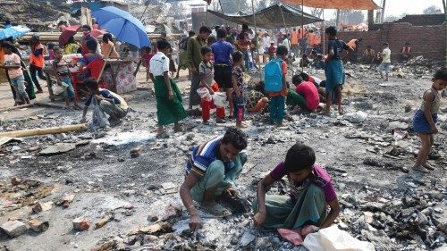Rohingya refugees search for valuables amid the debris days after a fire burnt their home at a ...