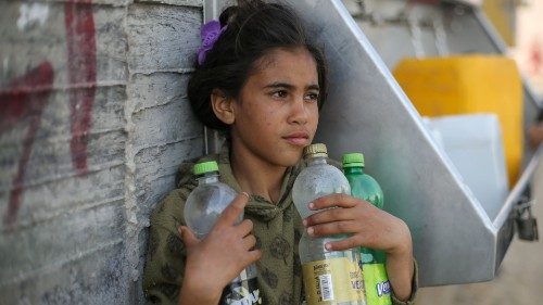 A Palestinian girl waits to fill bottles with water from a public tap in the southern Gaza Strip ...
