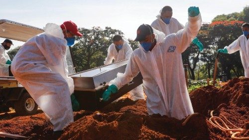epa09093895 Workers place a coffin inside a grave in the Vila Formosa cemetery in Sao Paulo, Brazil, ...