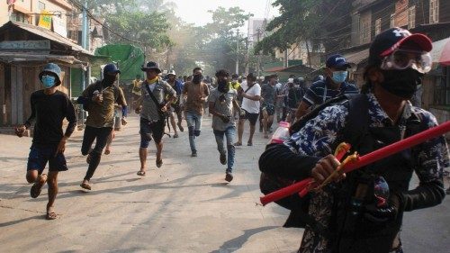 Men run during a protest against the military coup, in Yangon, Myanmar March 28, 2021. ...