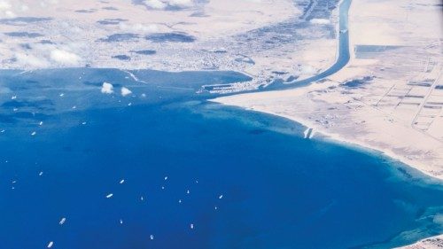 An aerial view taken on March 27, 2021 from the porthole of a commercial plane shows stranded ships ...