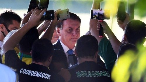 TOPSHOT - Brazilian President Jair Bolsonaro talks to supporters as he leaves the Alvorada Palace in ...