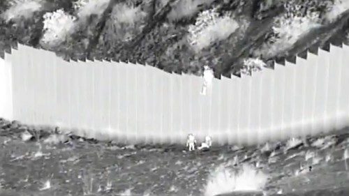 A screengrab from camera footage shows two toddlers as they are dropped over a border barrier in the ...