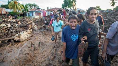 A woman cries over her relative who was found dead in after heavy rain brought flash floods in East ...