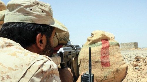 A fighter with forces loyal to Yemen's Saudi-backed government holds a position against Huthi rebels ...