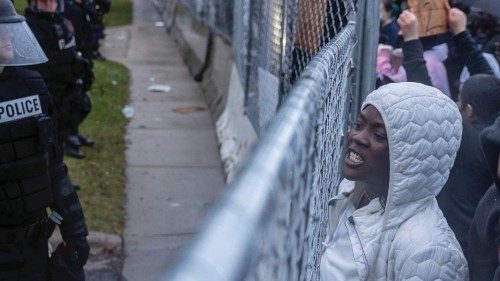 TOPSHOT - People shout towards the Police at the start of curfew to protest the death of Daunte ...