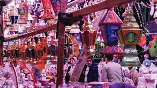 People shop from a stall selling Ramadan lanterns along a main street in the Shubra district of ...
