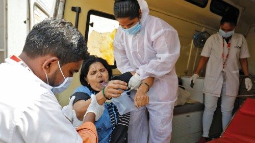 A patient with breathing problems is helped aboard an ambulance as she is being shifted to a ...