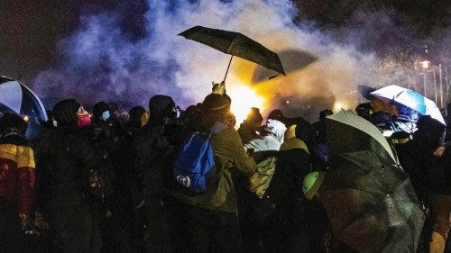 TOPSHOT - Demonstrators use umbrellas to shield themselves against tear gas and pepper balls outside ...