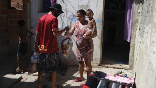 Kelly Cristina Moraes, 33, carries her 1-year-old son Josue as she receives donated food from 'Uma ...