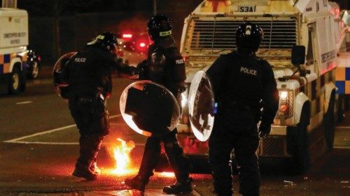 Police officers are seen next to fire during a protest in the Loyalist Tigers Bay Area of Belfast, ...