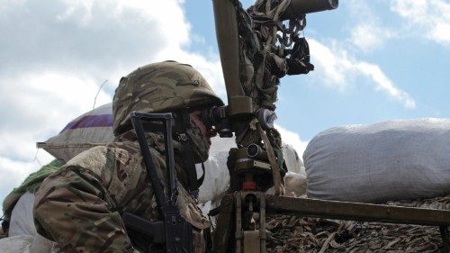 A service member of the Ukrainian armed forces uses periscopes while observing the area at fighting ...