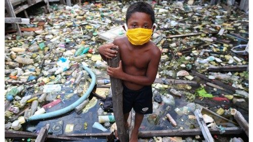 TOPSHOT - A boy from the Educandos riverside community wears a face mask during the COVID-19 ...