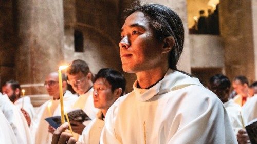 Ein Priester hält eine brennende Kerze in den Händen während der Chrisammesse in der Grabeskirche in ...