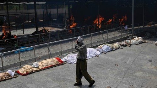 A man walks past bodies of Covid-19 coronavirus victims lined up before cremation at a cremation ...