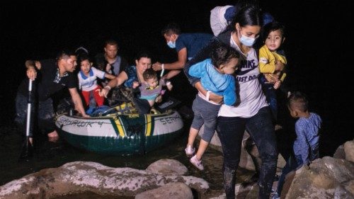 ROMA, TEXAS - APRIL 30: An immigrant mother carries her children up the bank of the Rio Grande after ...