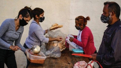 Women serve food at a soup kitchen at the Puerta de Hierro neighborhood, in La Matanza municipality, ...