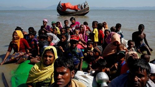 FILE PHOTO: Rohingya refugees sit on a makeshift boat as they get interrogated by the Border Guard ...