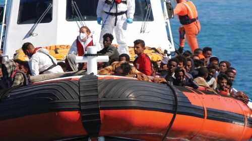 Migrants approach aboard a search-and-rescue boat after hundreds arrive on the southern island of ...