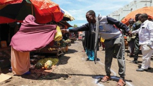 A Somali woman sells fruits to a customer standing at a social distancing marker in late April in ...