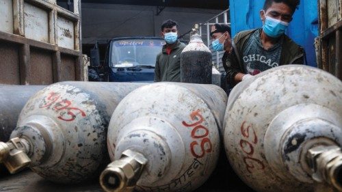 A man loads cylinders with medical oxygen for Covid-19 coronavirus patients outside an oxygen ...