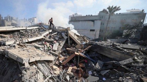 A member of the Palestinian civil defence walks amidst the rubble of a building in Gaza city which ...