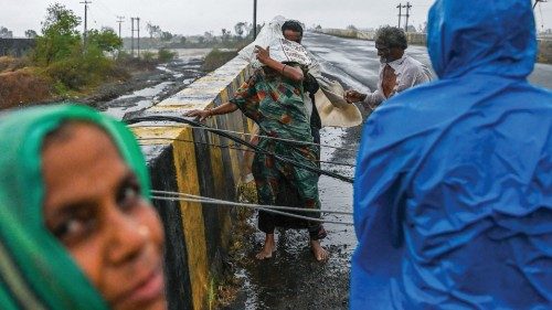 Villagers try to cross fallen down electricity cable on a bridge near Diu on May 18, 2021, after ...