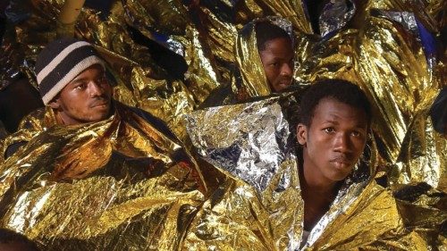 Migrants and refugees wrapped in survival foil blankets rest aboard the Topaz Responder ship run by ...