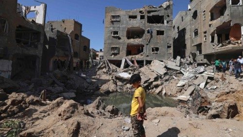 TOPSHOT - A Palestinian child stands amidst the rubble of buildings, destroyed by Israeli strikes, ...