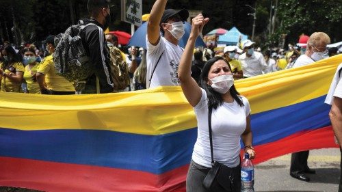 People wave the Colombian national flag during a demonstration in opposition to road blockades and ...