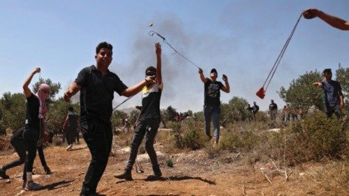 Palestinian protestors throw rocks at Israeli security forces during clashes in the village of ...