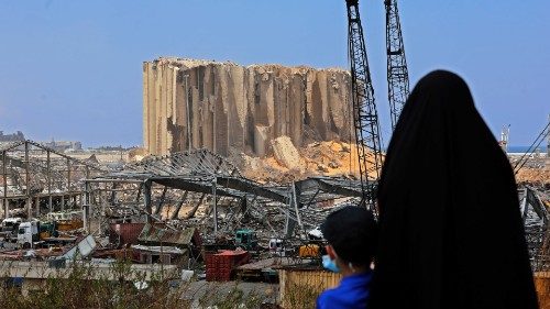 A woman with her boy contemplate the damaged grain silos at the port of Beirut following a huge ...