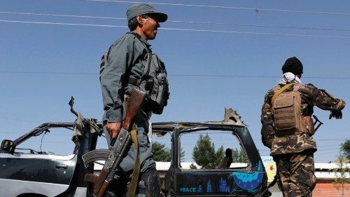 FILE PHOTO: Afghan police officer inspects a damaged van after a blast in Kabul, Afghanistan June 3, ...