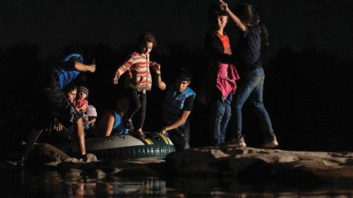 Asylum-seeking migrant families disembark from an inflatable raft after crossing the Rio Grande ...