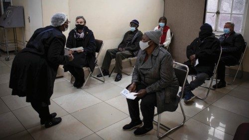 Infermiera parla con anziani sudafricani mentre aspettano di ricevere il vaccino anti-covid a Johannesburg (Ansa)