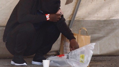 A migrant rests inside a Red Cross tent in the port of Arguineguin, on the island of Gran Canaria,  ...