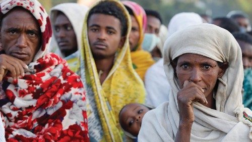 A woman stands in line to receive food donations, at the Tsehaye primary school, which was turned ...