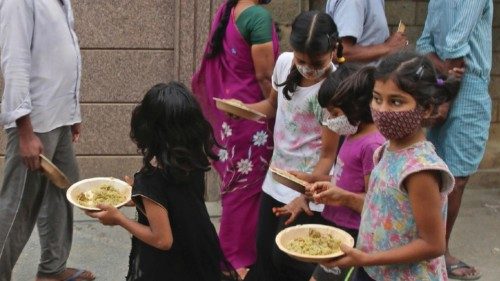 epa09266543 Children walk  near a foot path after collecting free food during an extended lockdown ...