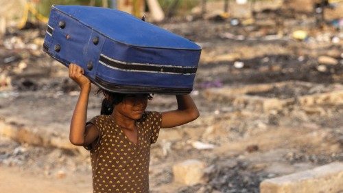 A Rohingya refugee carries her belongings to a temporary shelter after a fire destroyed a Rohingya ... A Rohingya refugee carries her belongings to a temporary shelter after a fire destroyed a Rohingya ...