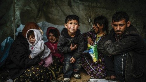 A Syrian refugee family from Aleppo, stay under a shelter during a rainy day on March 8, 2014, at ...