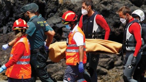 Rescue workers carry the body of a dead person after a boat with 46 migrants from the Maghreb region ...