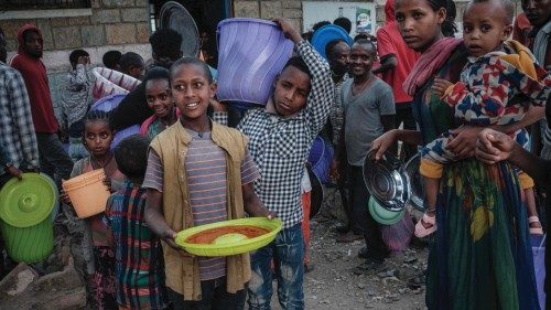 Children carry injeras, Ethiopia's staple food of sour fermented flatbread, and soup for their group ...