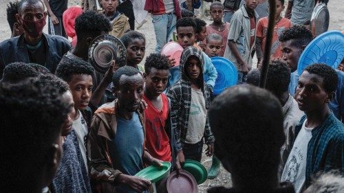 People wait to receive their dinner for their groups at May Weyni elementary school, now hosting ... People wait to receive their dinner for their groups at May Weyni elementary school, now hosting ...