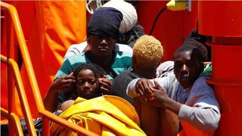 Migrants wait to disembark from a Spanish coast guard vessel, in the port of Arguineguin, on the ...
