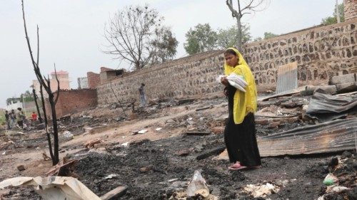 epa09266584 A Rohingya Muslim woman walks with relief material in her hand after a fire damaged ...