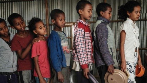 Children, who fled the violence in Ethiopia's, Tigray region, wait in line for breakfast organized ...