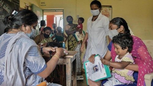 A pediatrician (L) conducts a general health checkup on a child at a government rural child health ...